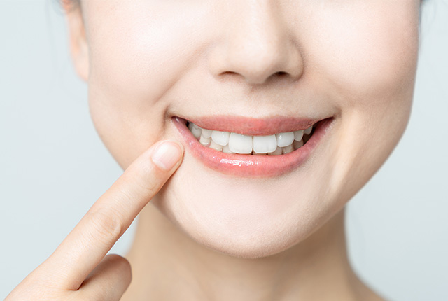 女性が歯を見せて笑った口元