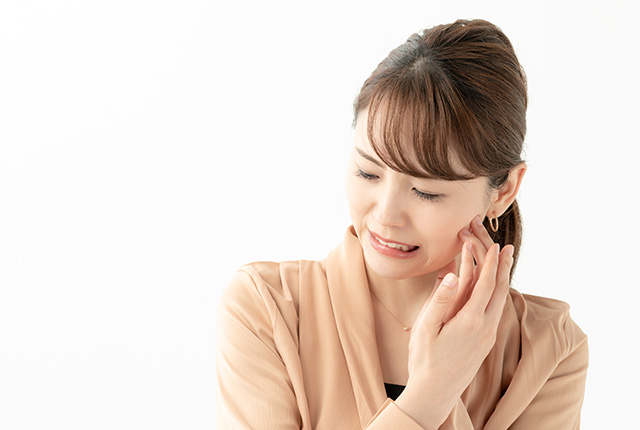 頬を痛そうにおさえる女性